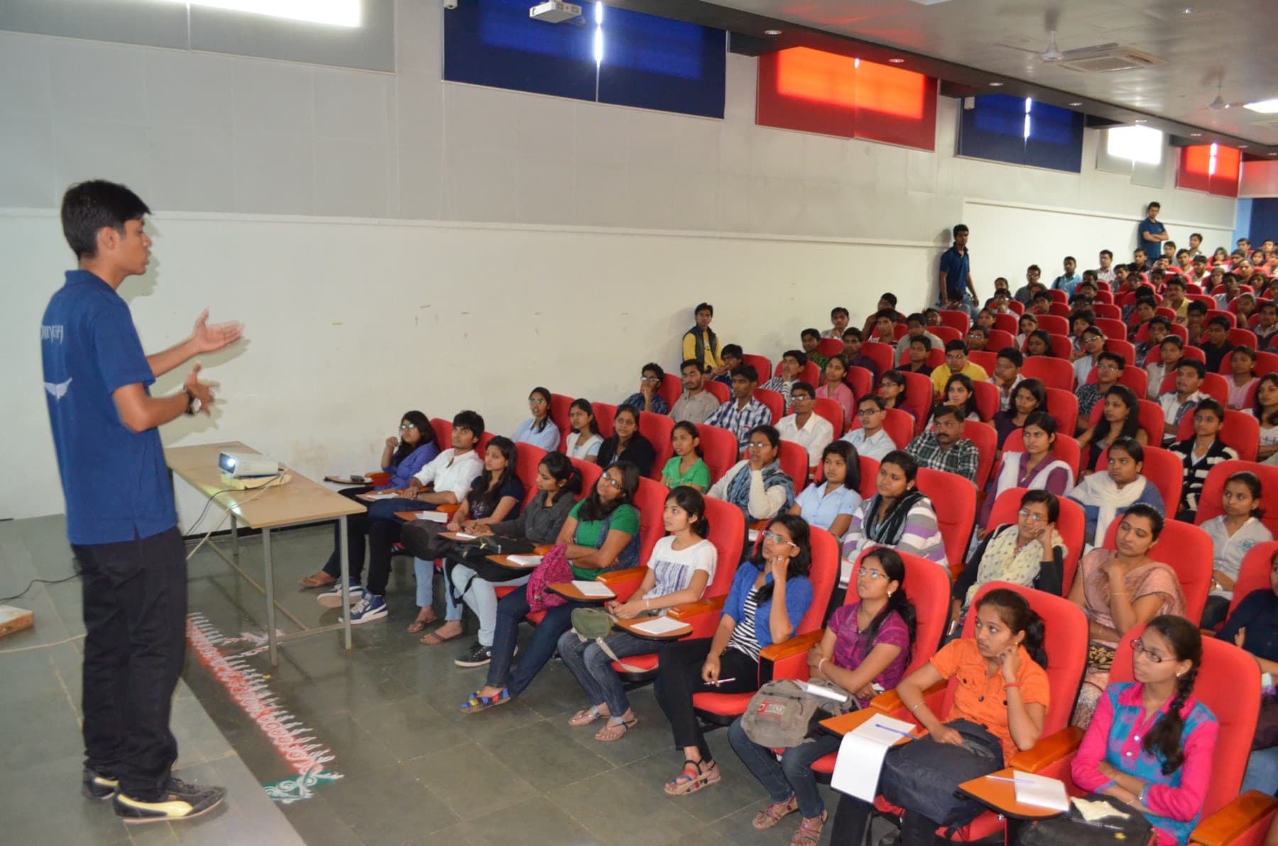 Dinesh Modi speaking to students in a college auditorium